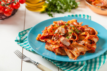Pappardelle pasta with tuna, in tomato sauce.