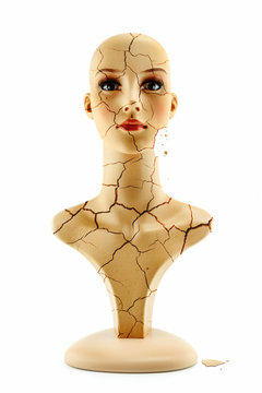 mannequin woman head fake without hair with craked skin isolated on white background