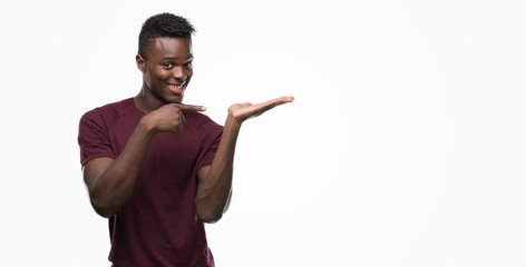 Young african american man very happy pointing with hand and finger
