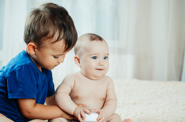 brother communicates and plays with her younger sister six months old