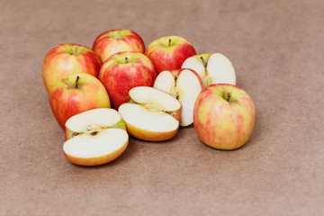 halves of red apples on a brown background