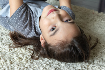 beautiful girl lies on a fluffy carpet