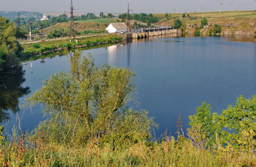 Large, beautiful, reflecting the sky pond. Near to it there is a road