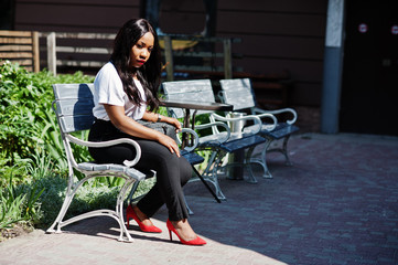 Stylish african american business woman on streets of city.