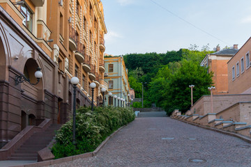 A promenade with beautiful buildings and decorative green bushes on the sides