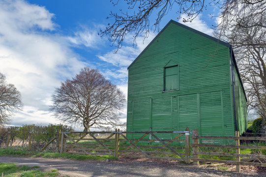 A rural farm shed painted in green at a farmland in British countryside of England, UK