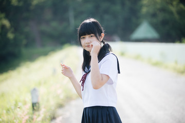 Fototapeta na wymiar Portrait of asian japanese school girl costume looking at park outdoor film vintage style