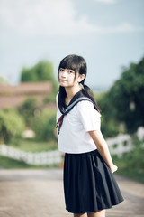 Portrait of asian japanese school girl costume looking at park outdoor film vintage style