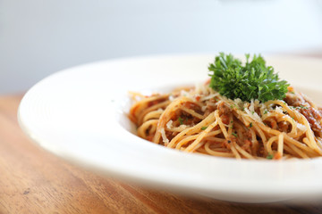 spaghetti Bolognese with minced beef and tomato sauce garnished with parmesan cheese and basil , Italian food