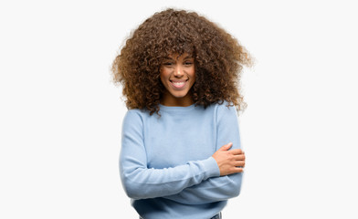 African american woman wearing a sweater happy face smiling with crossed arms looking at the camera. Positive person.