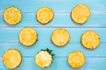 Tropical pineapple slices on wood plank blue color. summer fruit backgrond concept, top view, pattern