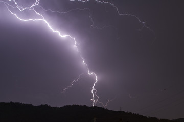 Thunderbolt falling on a power line of a village