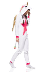 A side view of a young Asian woman wearing a unicorn kigurumi costume with a tail, gold wings and...