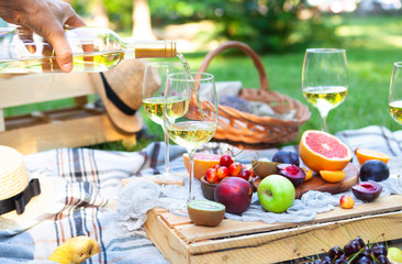 Picnic background with white wine and summer fruits on green grass, summertime party - 211900685