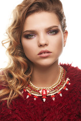 Close up portrait of a young fair-haired lady with one sided hairstyle. The girl in a red shaggy...