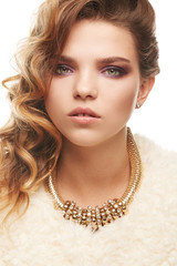 Close up portrait of a young fair-haired lady with one sided hairstyle. The girl in an ivory shaggy...