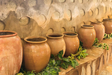 Fototapeta na wymiar old clay pots standing in a row. Big jars with water