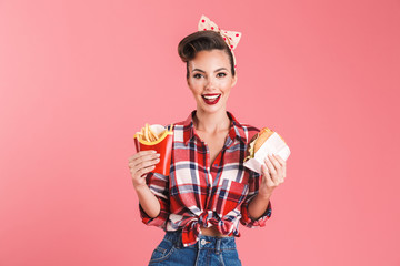 Young pin-up woman holding french fries and burger.