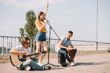 Multiracial young people performing singing on street