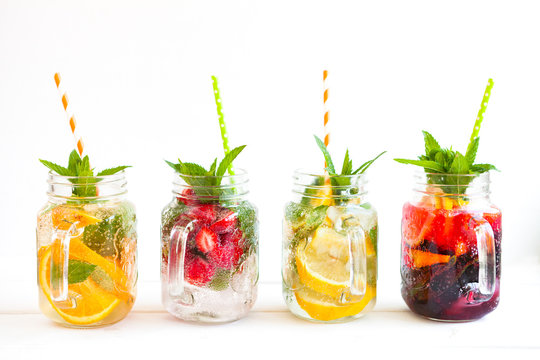 Homemade iced lemonade with mint, summer fruits and berries in a mason jar. Copy space background