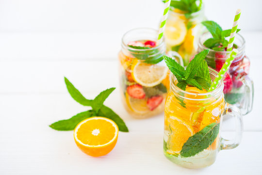 Homemade iced Fresh lemonade with mint, summer fruits and berries in a mason jar. Copy space background.