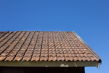 Old red roof tiles with beautiful blue sky background