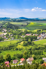 Countryside landscape in the valley, panoramic view of town with houses on foothills with green...