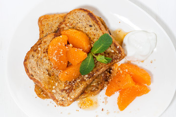 sweet french toast with jam and tangerines for breakfast, top view