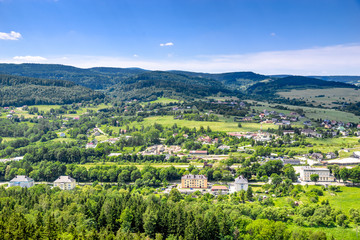 Fototapeta na wymiar Mountain town in the valley with green and houses, aerial view