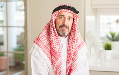 Middle age arabian man at home with a confident expression on smart face thinking serious