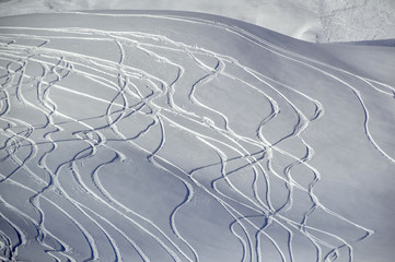 Traces of snowboarding on fresh snow.