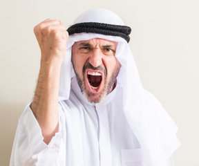 Senior arabic man annoyed and frustrated shouting with anger, crazy and yelling with raised hand,...