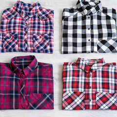 Four multi-colored checkered women's shirts lying neatly folded