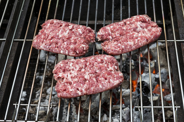 Raw Sausages cook on the grill