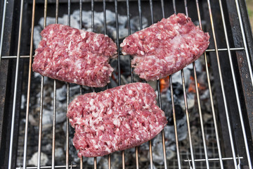 Raw Sausages cook on the grill