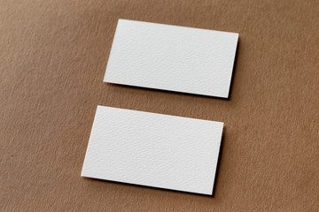 Mockup of two white business cards at craft textured paper background.