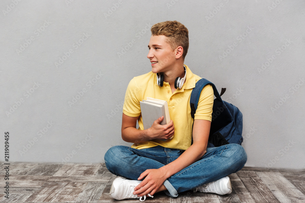 Wall mural portrait of a smiling casual teenage boy with backpack