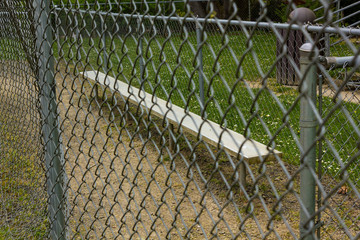 fence and bench at baseball field at park