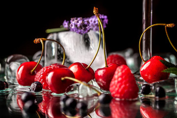 berry cold cocktail with alcohol in a glass crystal glass on a black background with berries,...