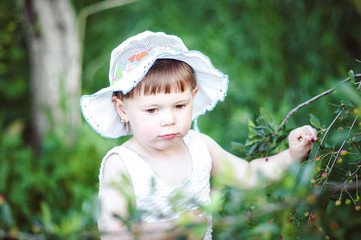 happy little girl playing on nature sitting on tree