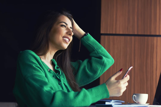 Woman typing write message on smart phone in a modern cafe cropped image of young pretty girl. happy woman writing message in phone while locating at counter in cafe break
