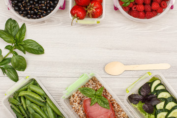 Plastic meal prep containers green peas, with boiled buckwheat porridge and slices of meat, fresh cucumbers and salad, currant, strawberry, raspberry