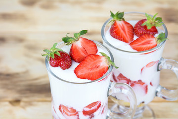 Spring strawberry dessert with organic yogurt and granola on a rustic table 