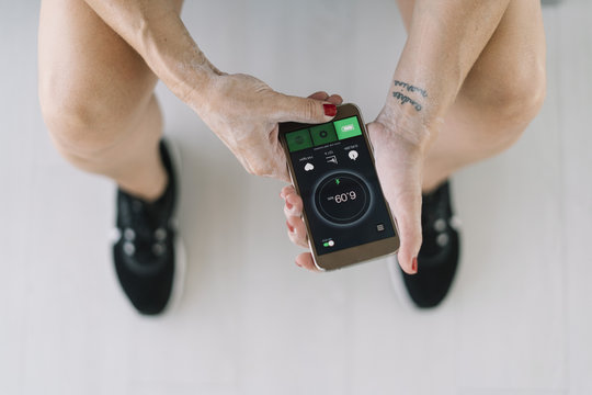 Faceless woman checking fitness app