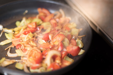 Green peppers onion and tomato on the grilled pan. Healthy breakfast.