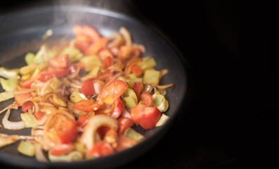 Green peppers onion and tomato on the grilled pan. Healthy breakfast.