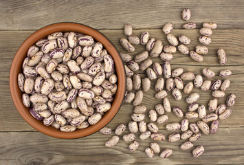 Haricot beans in bowl on wooden background
