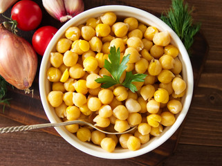 Cooked Chickpeas on bowl on dark wooden table. Healthy, vegetarian nutritious protein food of Middle East. Top view.