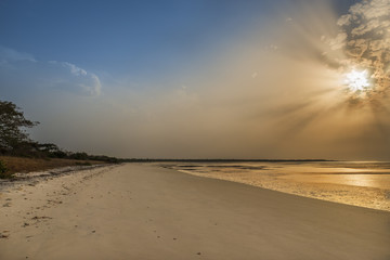 View of a beautiful deserted beach in the island of Orango at sunset, in Guinea Bissau. Orango is part of the Bijagos Archipelago; Concept for travel in Africa and summer vacations