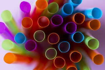 Colorful straws on a pink background